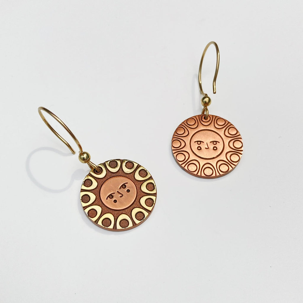 Reverse detail: Helios solar earrings seconds in 24k gold and antique copper. Shows a classic sun face relief back detail.