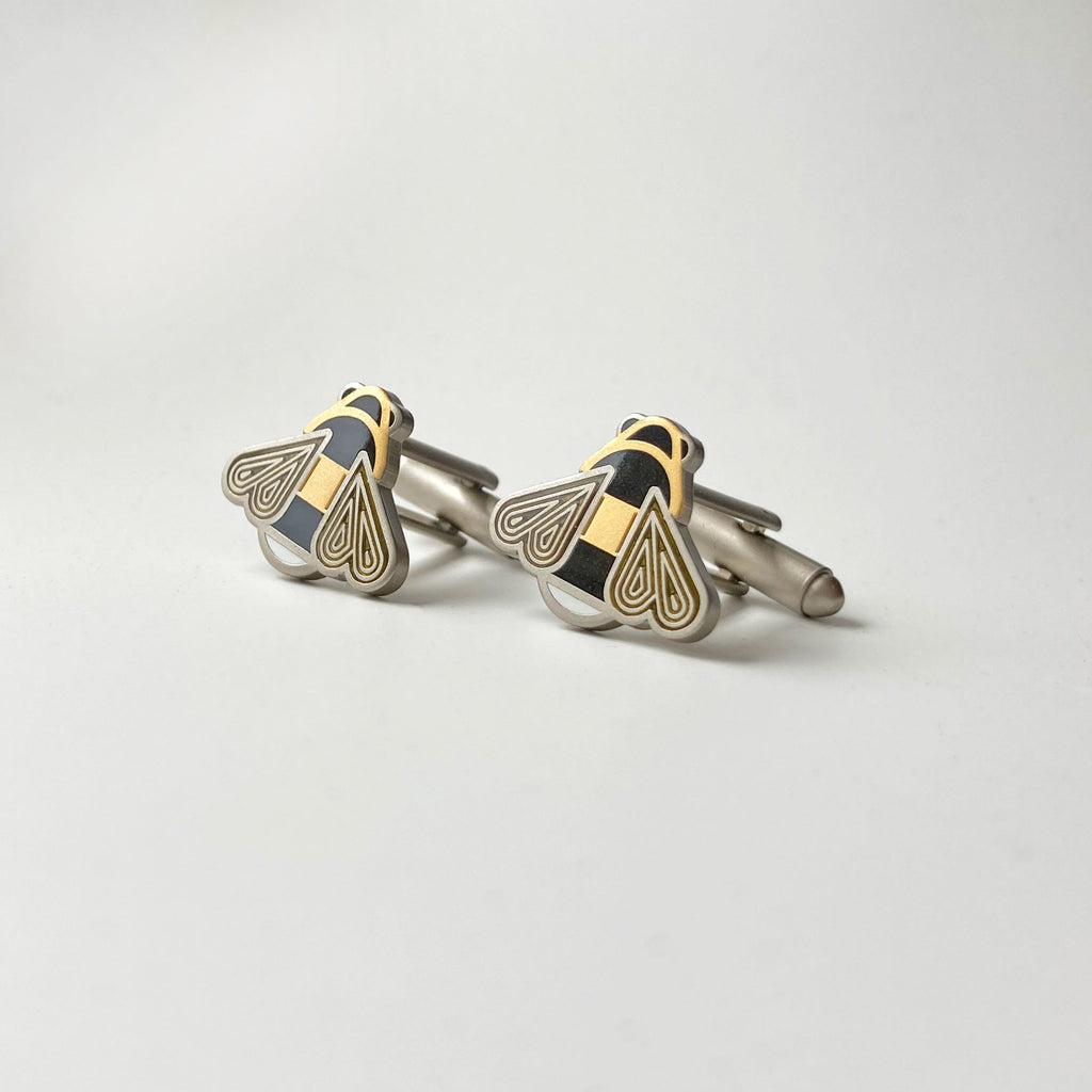 Mellona black and white enamel honeybee cufflinks finished in 24k gold and satin sterling silver with bullet toggle backs.